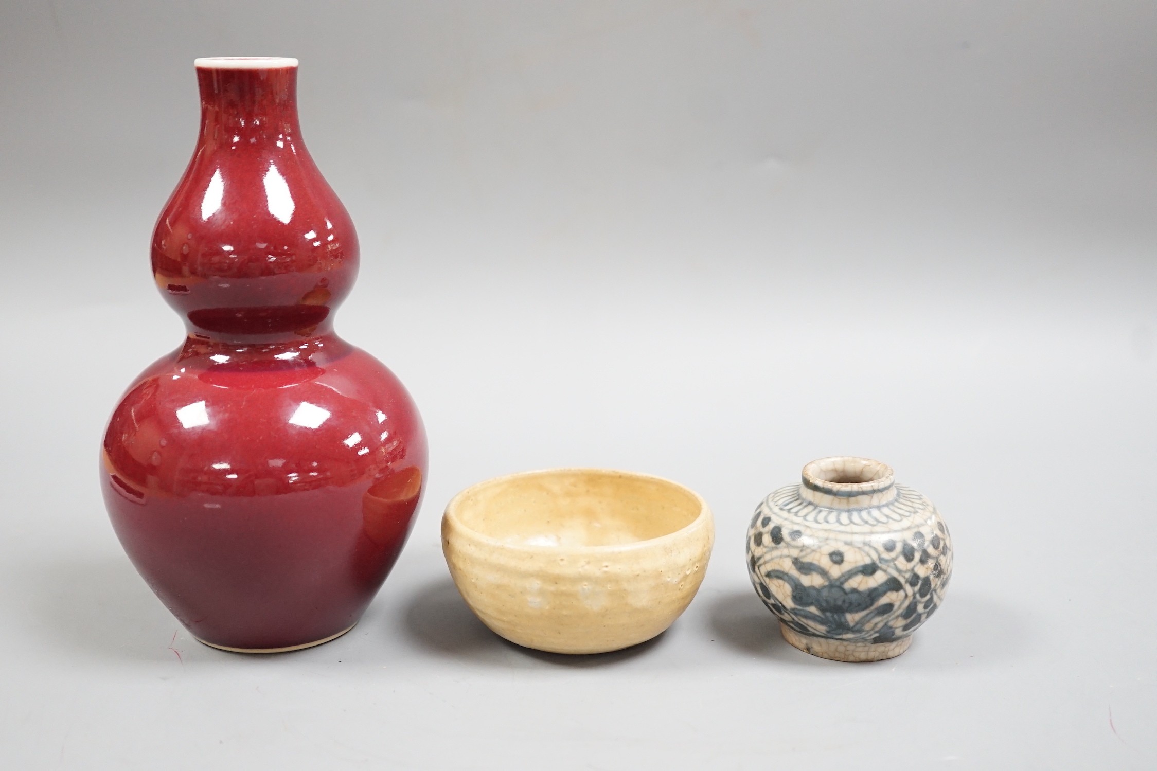 A Chinese sang de boeuf double gourd vase, a Swatow blue and white jarlet and a small cup, tallest 17cm